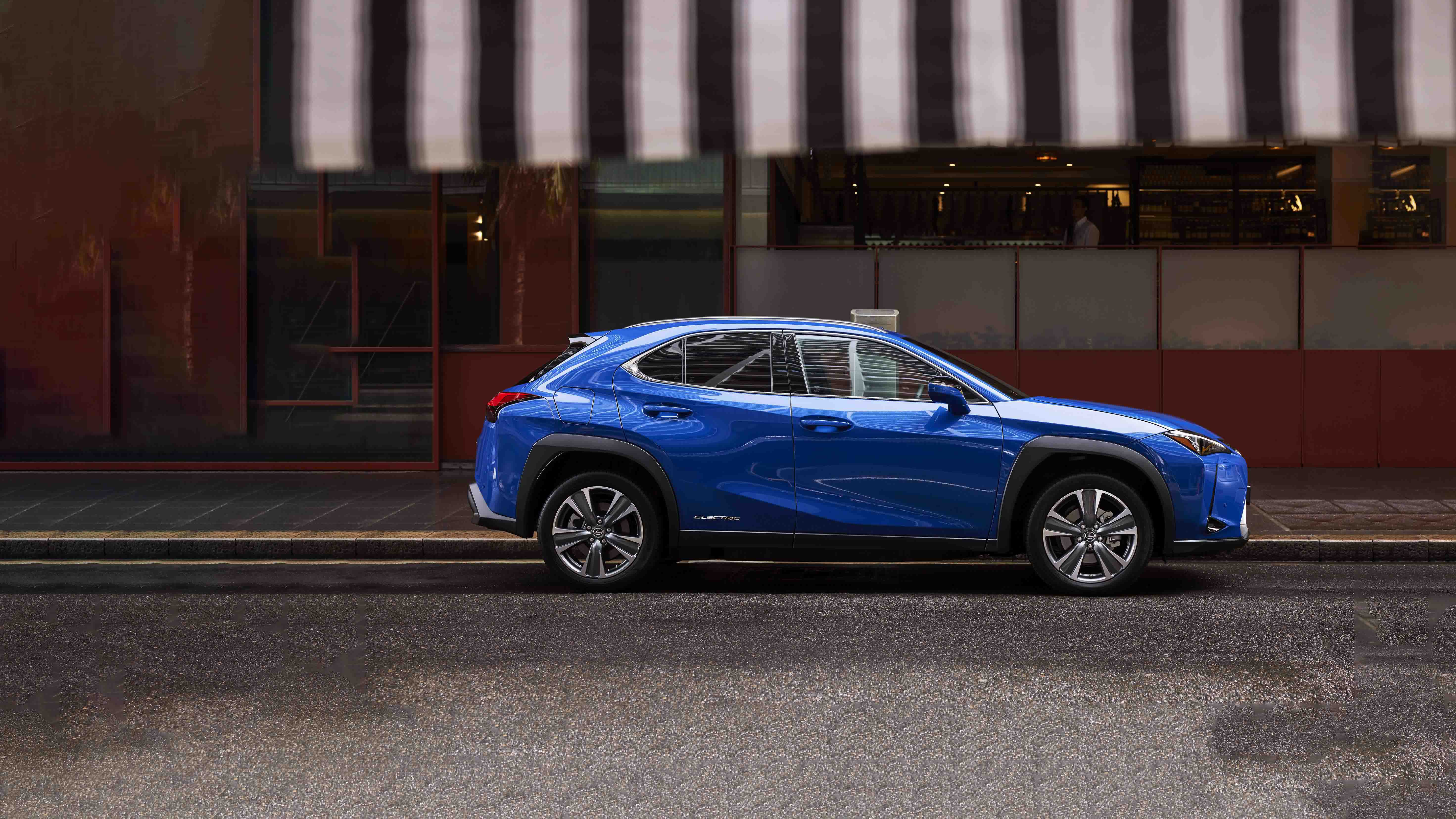 blue BEV sits parked on the street.