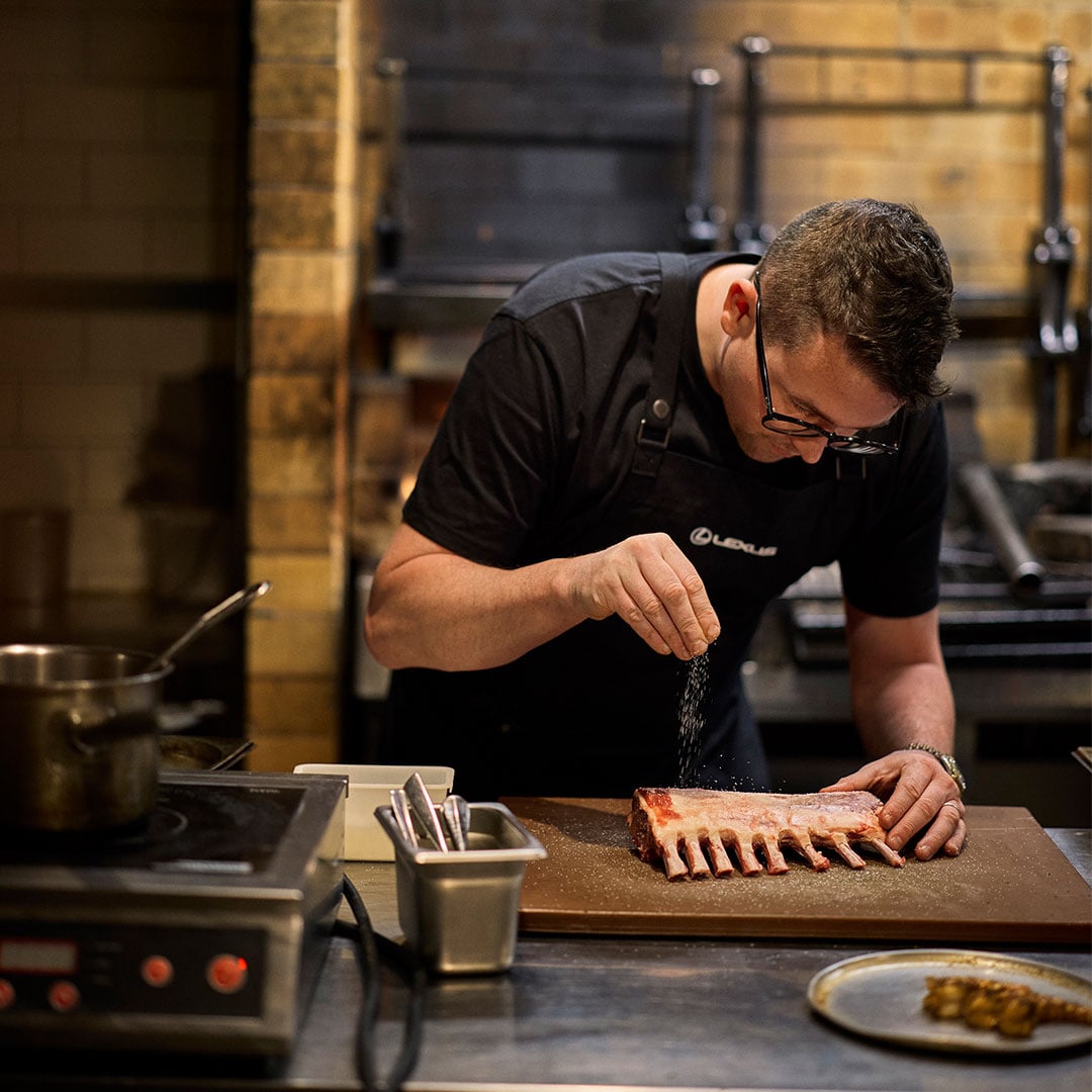 A chef prepares a rack of lamb