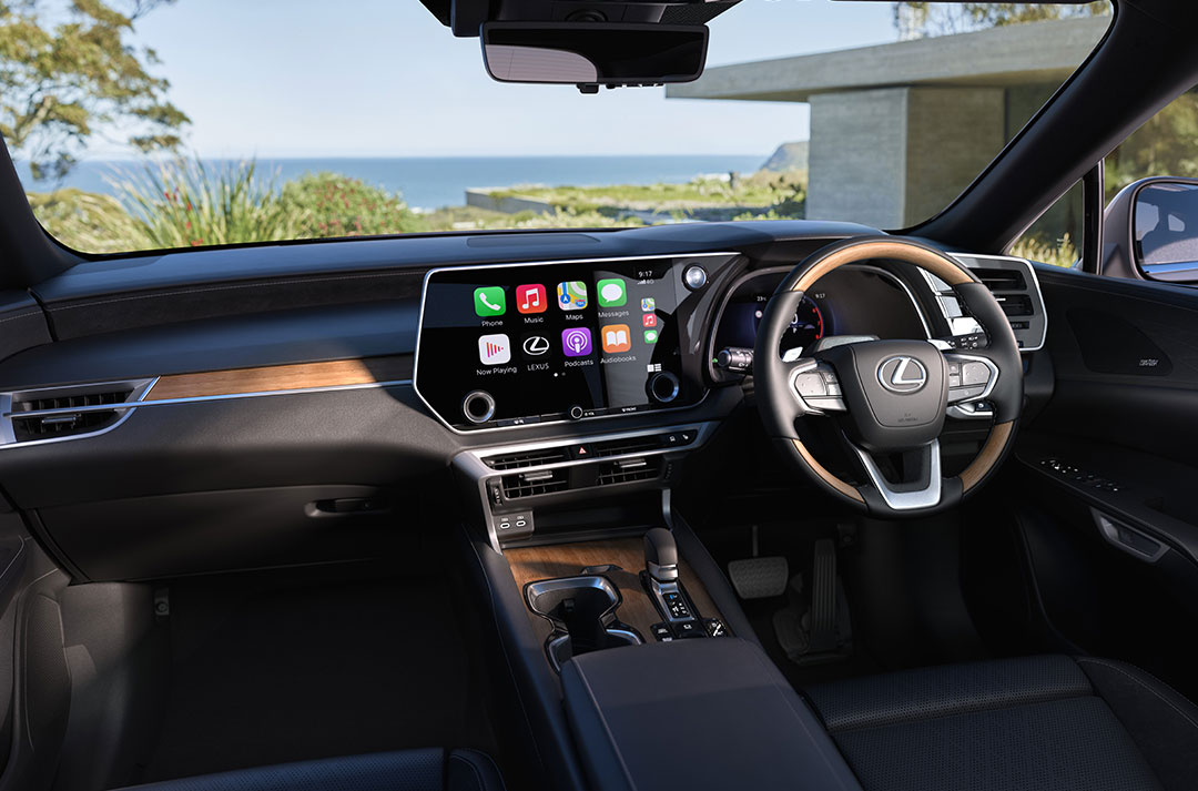 Interior of a Lexus RX showing the driver’s cockpit, steering wheel and central touchscreen