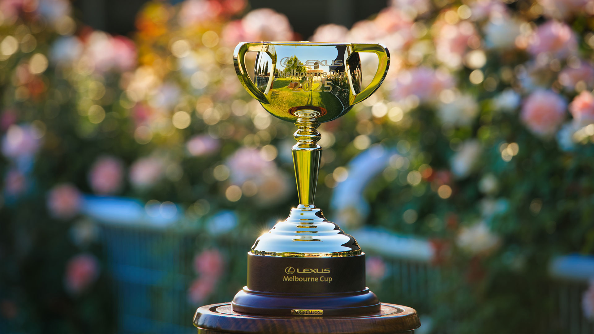 The golden Lexus Melbourne Cup 2025 trophy with flowers in the background
