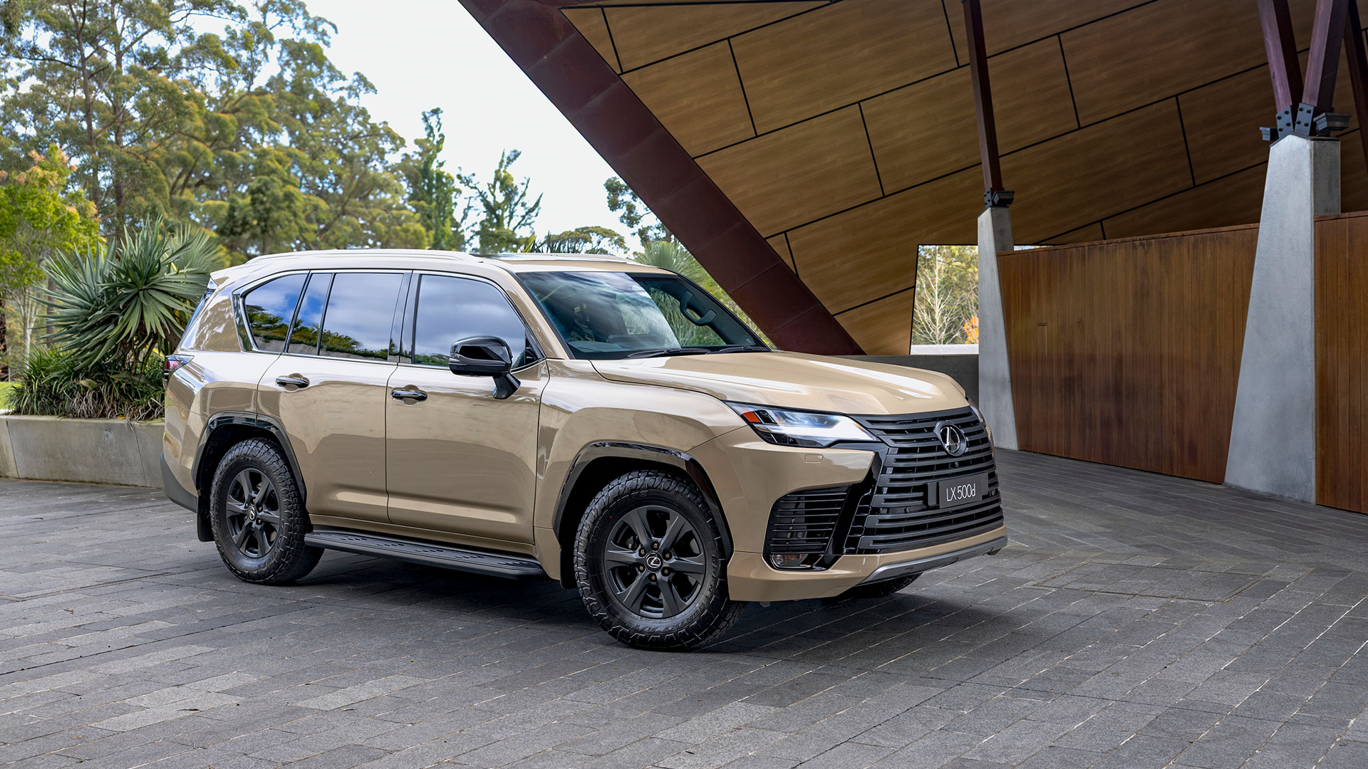 The Lexus LX 500d Overtrail in Earth tone parked outside a modern building